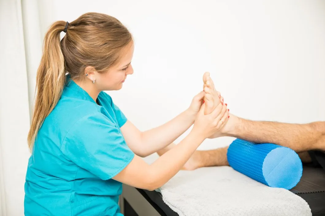 Female podiatrist examining patient's arch alignment for custom orthotics at Precision Podiatry in Alma