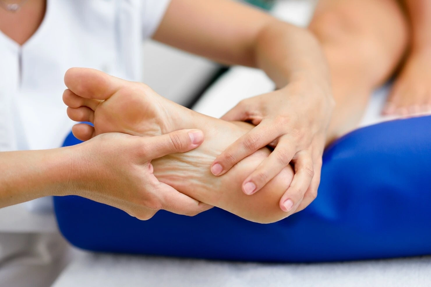 Podiatrist examining arch and plantar fascia for custom orthotics at Precision Podiatry in Alma