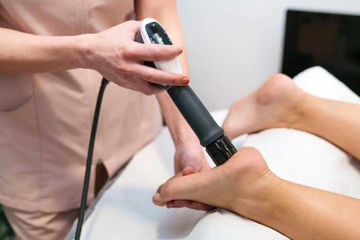 Podiatrist applying shockwave therapy for plantar fasciitis and heel pain at Precision Podiatry in Alma